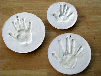 3 plaster prints of children's hands on table