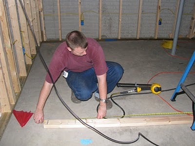 man framing basement wall