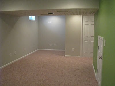 finished basement toy room with grey walls and carpet