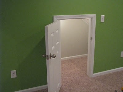 under the stairs door with green wall