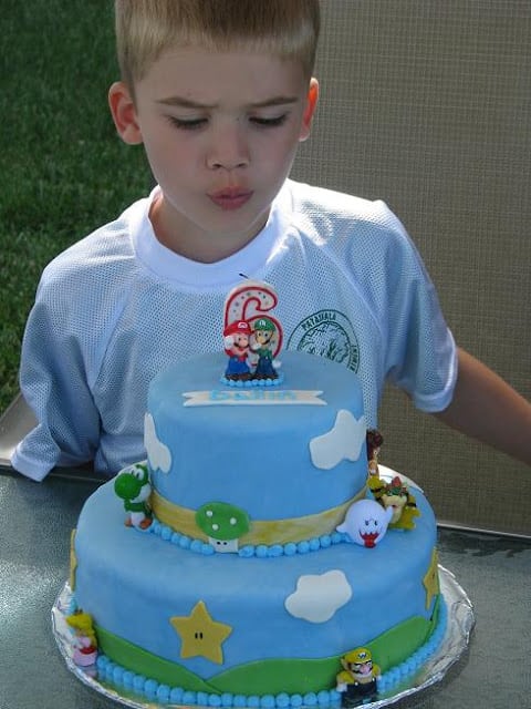 child blowing out candle on cake