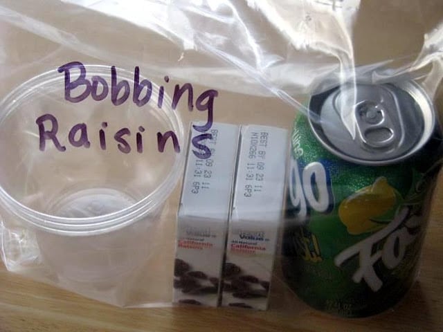 plastic cup and raisins and can of soda