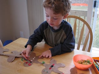 toddler decorating brown bag gingerbread man