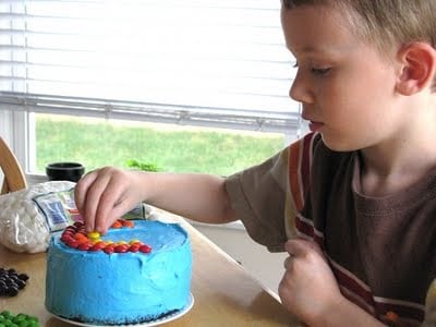 child with small cake with blue frosting 