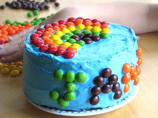 blue cake with skittles candy rainbow on top
