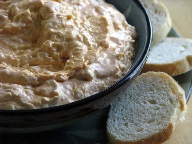 buffalo chicken dip in bowl with slices of bread to the side