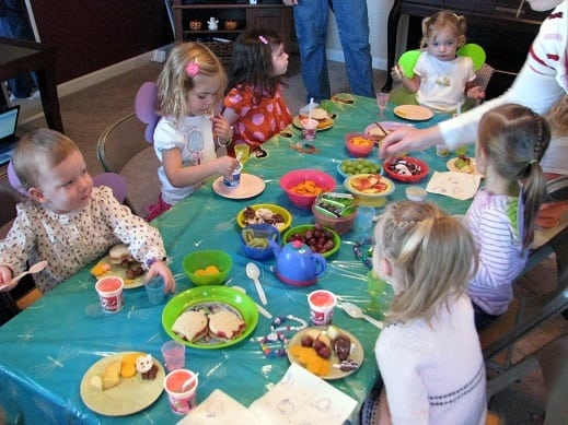 little girls sitting around table for birthday party