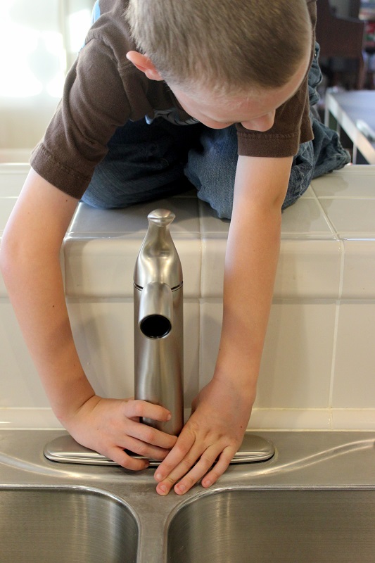 child helping remove faucet