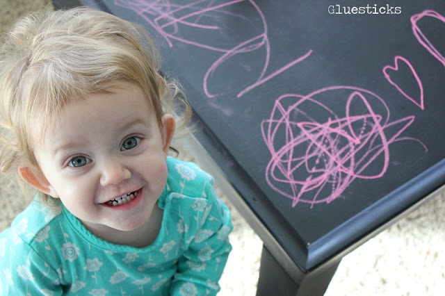 little girl next to chalkboard table