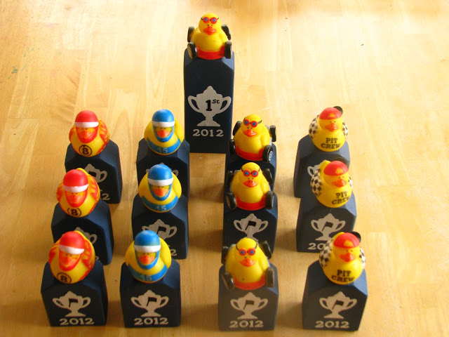 wooden pinewood derby trophies with rubber ducks on top