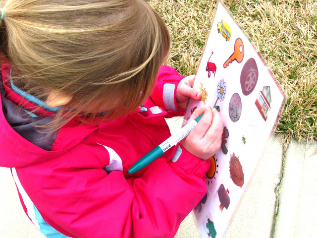 child marking off items on scavenger hunt