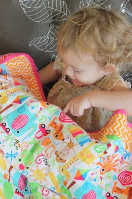 toddler with alphabet quilt