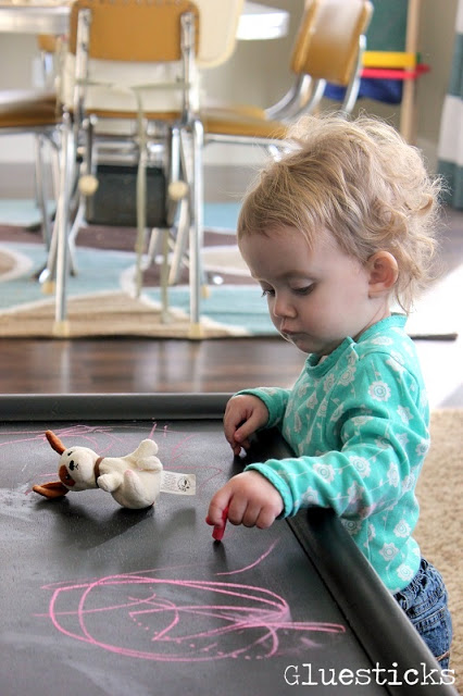 toddler drawing on chalkboard table