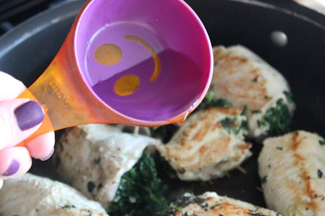 measuring cup adding chicken broth to pan