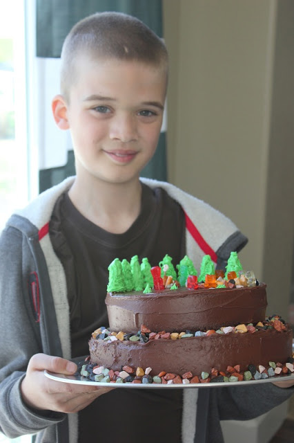 child holding camping cake on cake platter