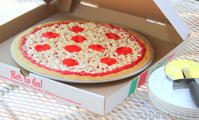 pizza box with pizza cookie and pizza cutter on top of serving plates