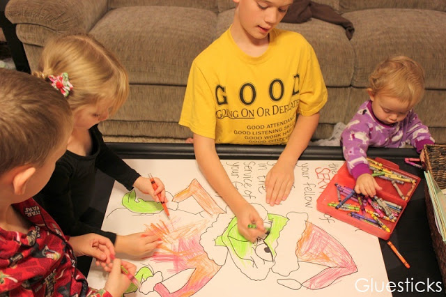 children sitting at table coloring grinch poster