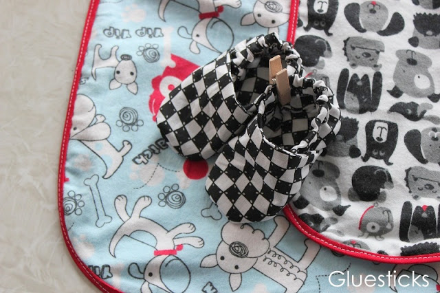 fabric baby shoes on top of receiving blanket