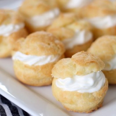 finished cream puffs on white platter
