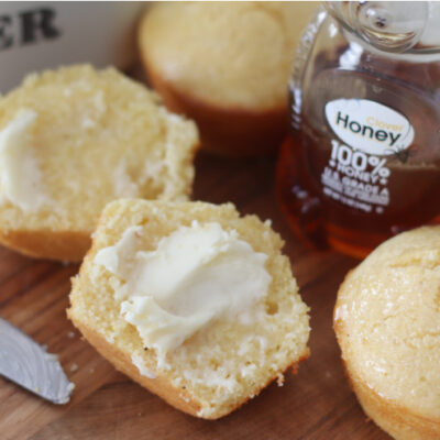 honey glazed cornbread muffin cut in half with butter