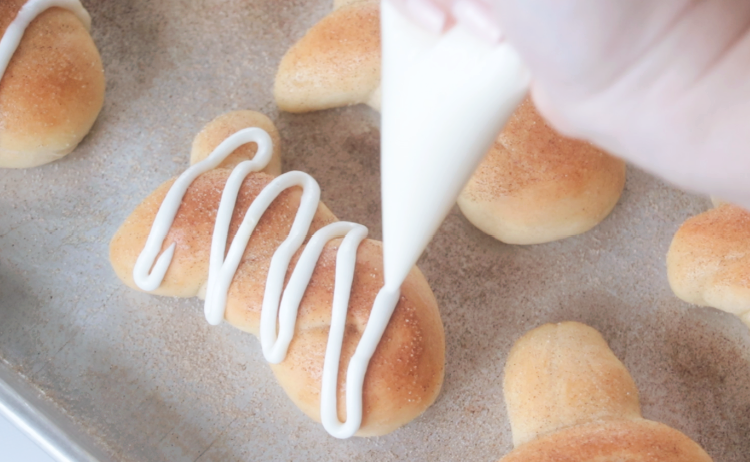 frosting drizzled over rolls