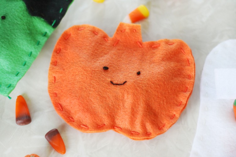 orange felt pumpkin pouch with face stitched on