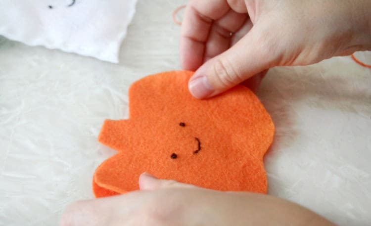 Two felt pumpkin cut outs stacked on top of eachother.