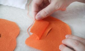 flap sewn over slit on felt pumpkin