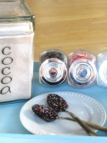 blue wooden tray with hot cocoa mix and chocolate spoons