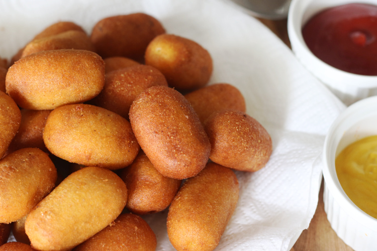 platter of corn dog bites next to bowls of ketchup and mustard