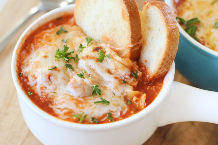 bowl of lasagna soup with cheese broiled on top