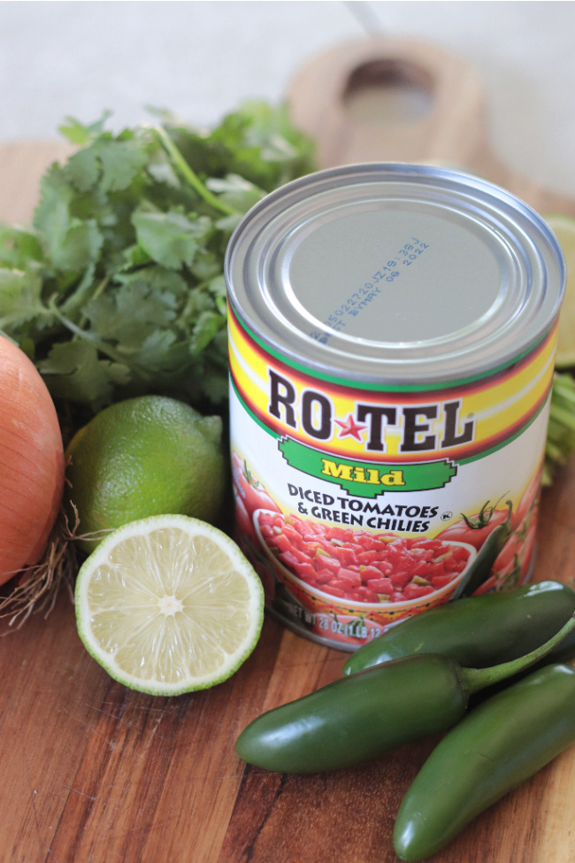 can of rotel, jalapeños, limes, onion and cilantro on cutting board