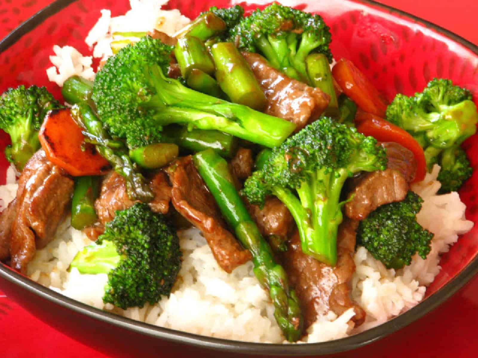 Bowl of beef and broccoli stir fry over white rice.