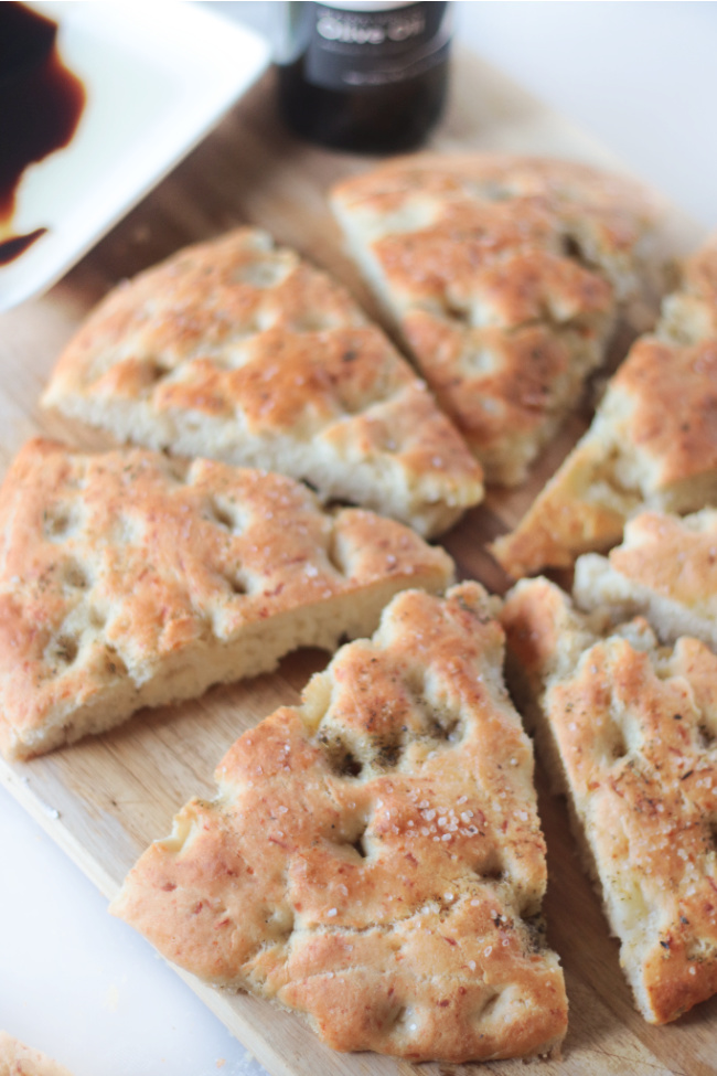 slices of parmesan focaccia bread on cutting board