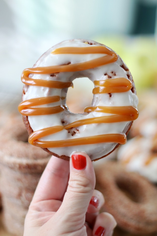 hand holding caramel drizzled apple cider donut