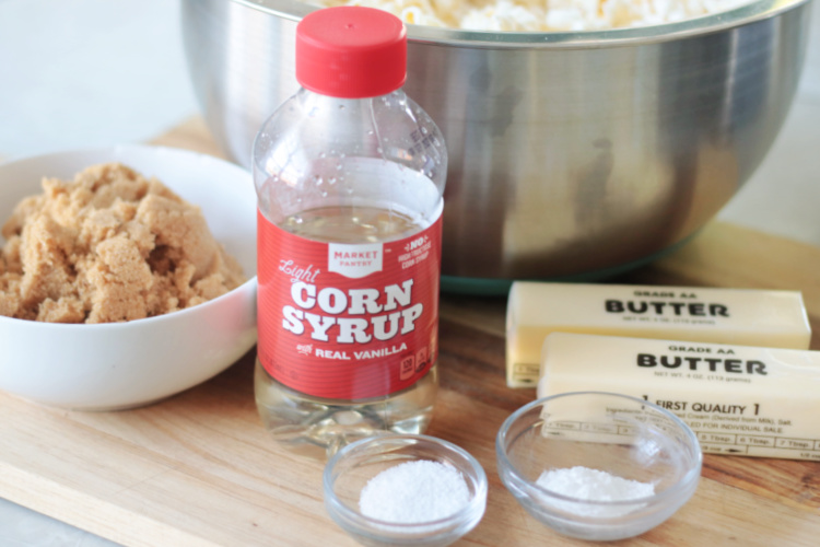 bottle of corn syrup, bowls of salt and baking soda, 2 sticks of butter and bowl of brown sugar