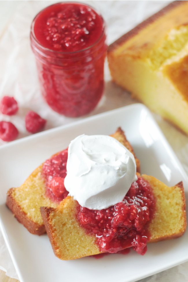 two slices of pound cake with raspberry sauce and whipped cream
