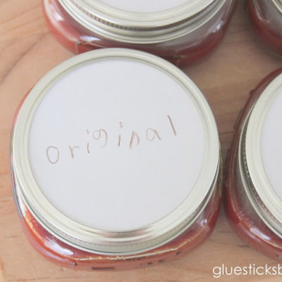4 small jars of bbq sauce with handwritten labels