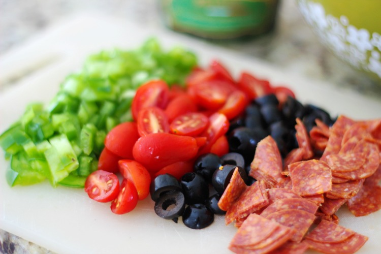 pasta salad ingredients diced on cutting board