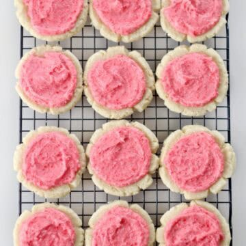 red hots cookies spread with frosting on cooling rack