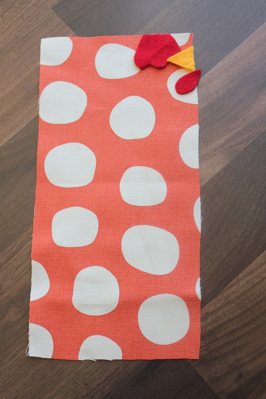 rectangle of orange fabric with felt pieces