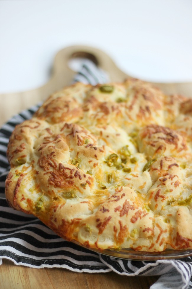 jalapeño cheese bread sitting on cutting board to cool