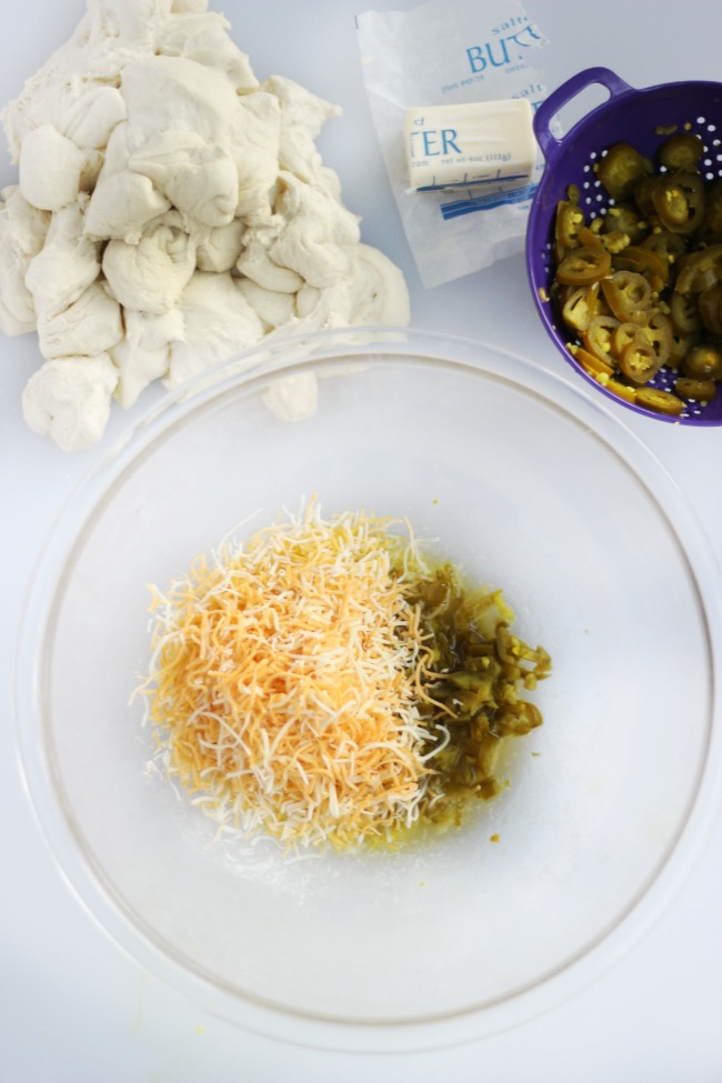 large glass bowl with shredded cheese, diced jalapeños and shredded cheese