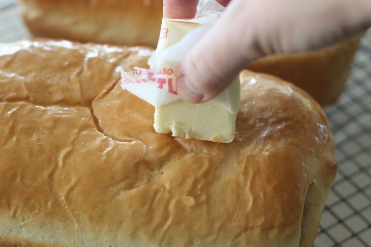 Brushing butter on hot bread straight from the oven 