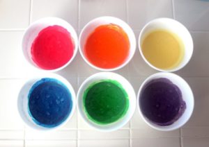 colored cake batter in bowls
