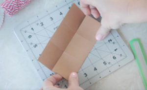 hands folding paper along scored lines