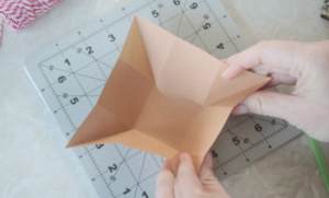 hands folding corners of paper box