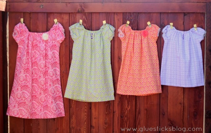 4 dresses hanging on a fence