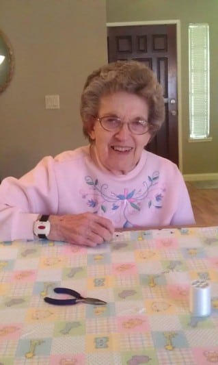 elderly woman quilting a quilt