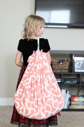 little girl holding fleece toy bag